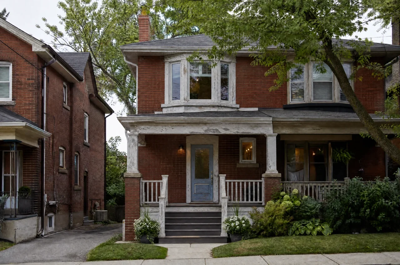 Before: red-brick house with peeling white trim and a faded door