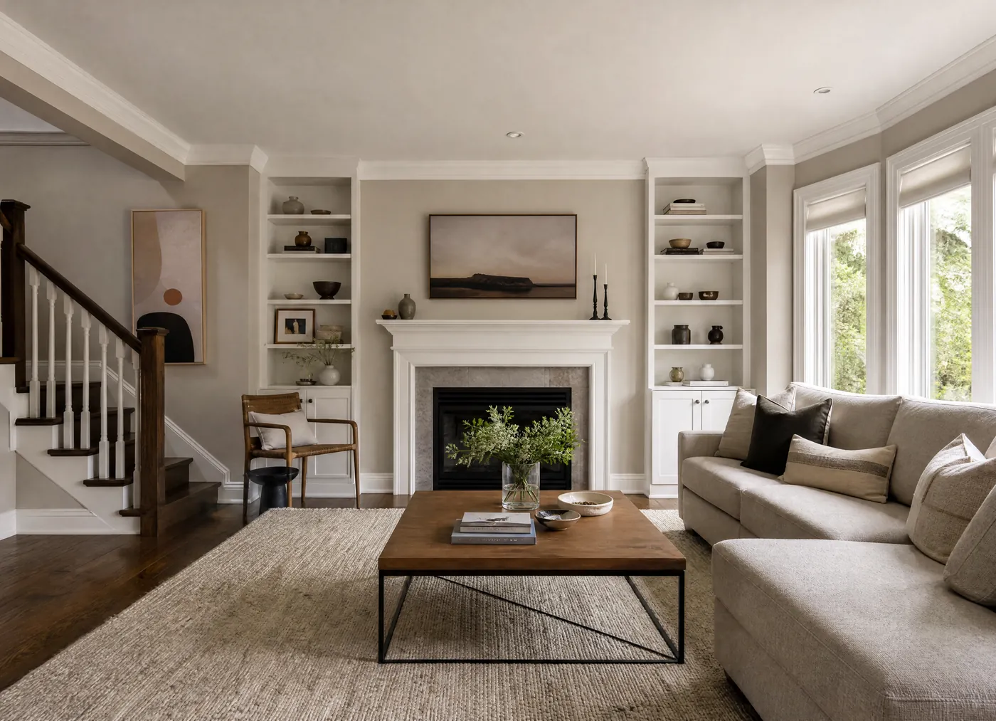 Bright living room freshly painted greige with a white fireplace mantel