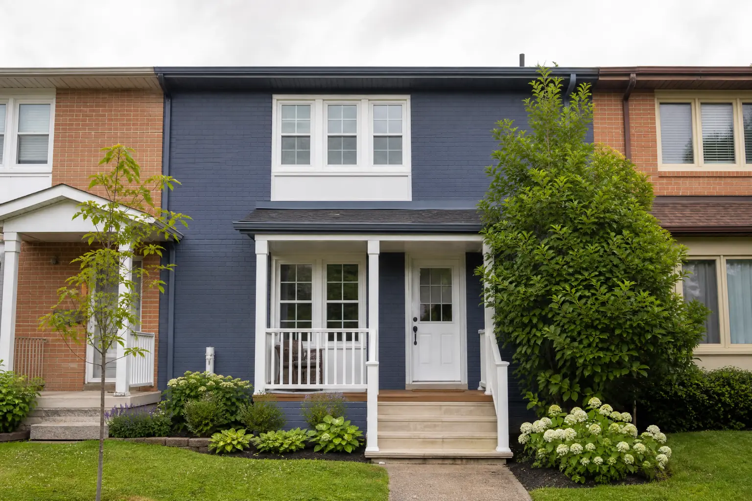 Brick townhouse front professionally painted slate blue with white trim