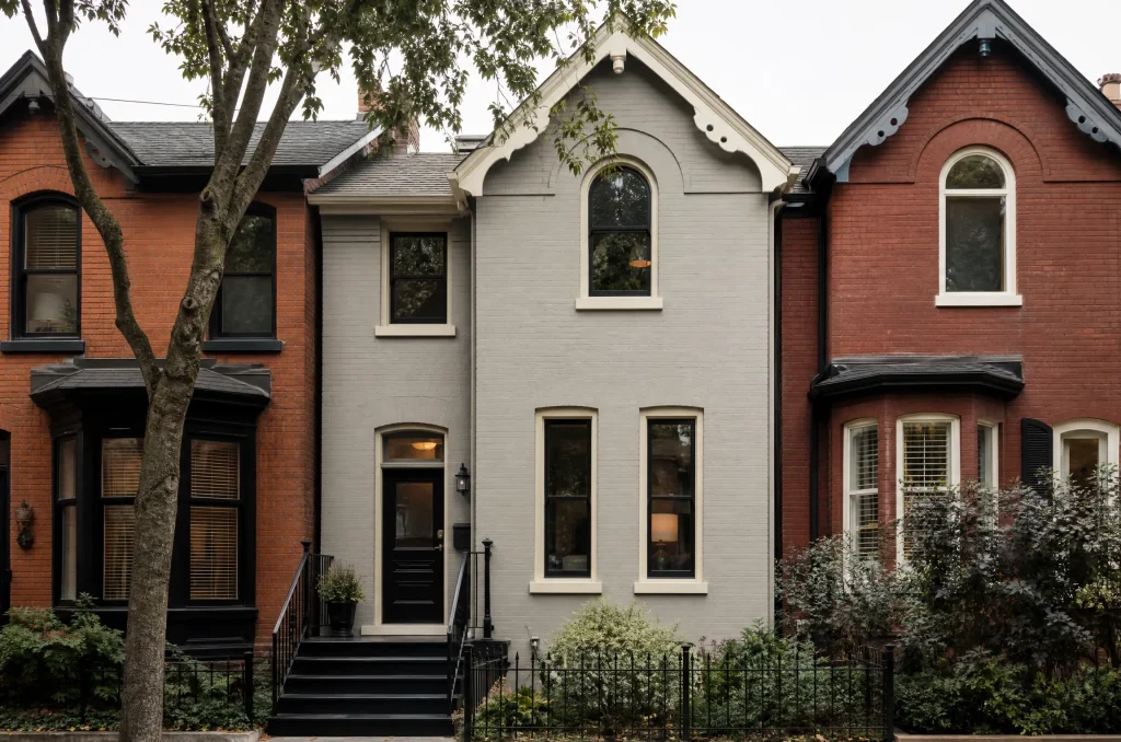 Victorian brick row house repainted soft grey with cream trim and a black door