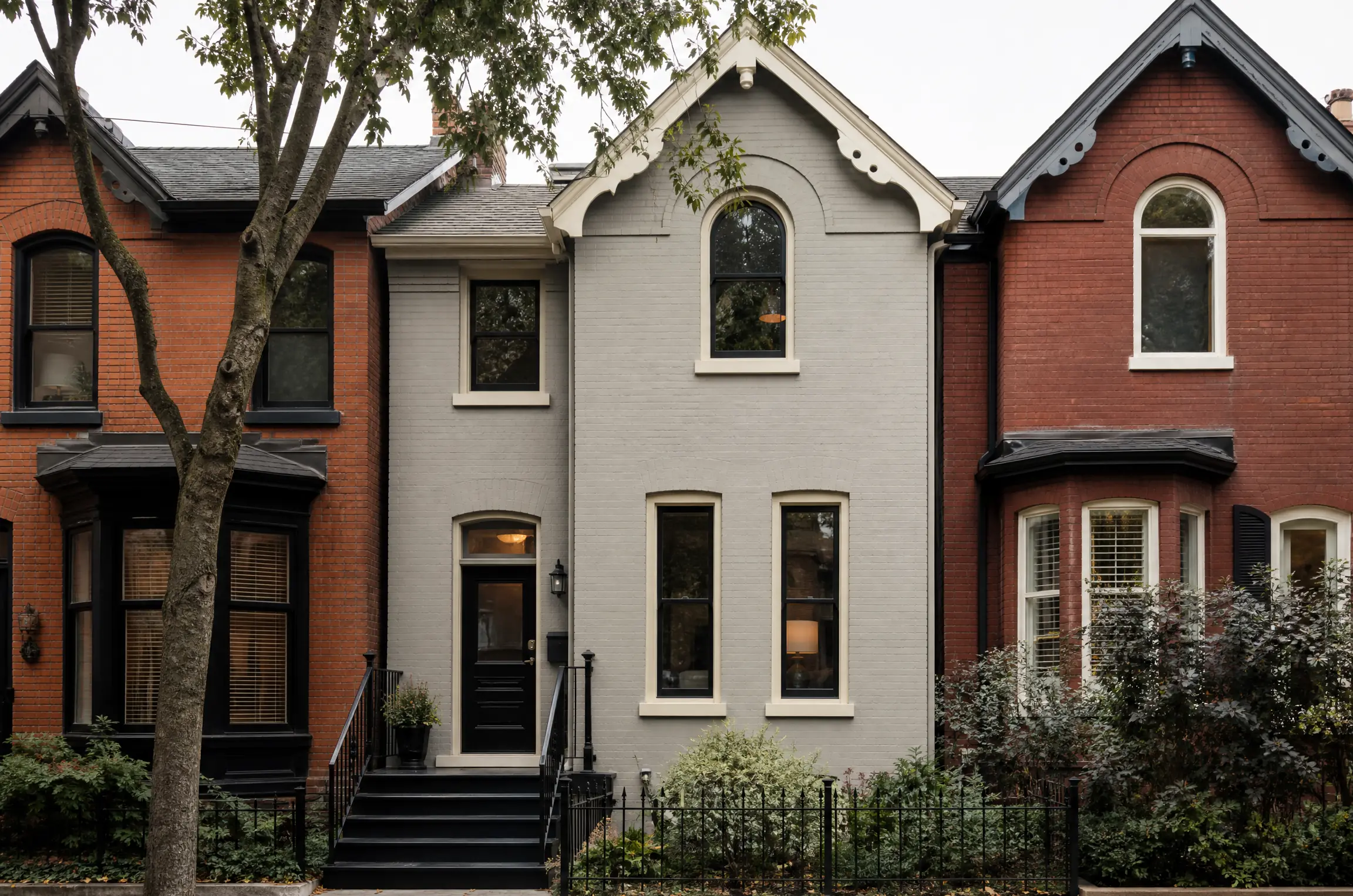 Victorian brick row house repainted soft grey with cream trim and a black door