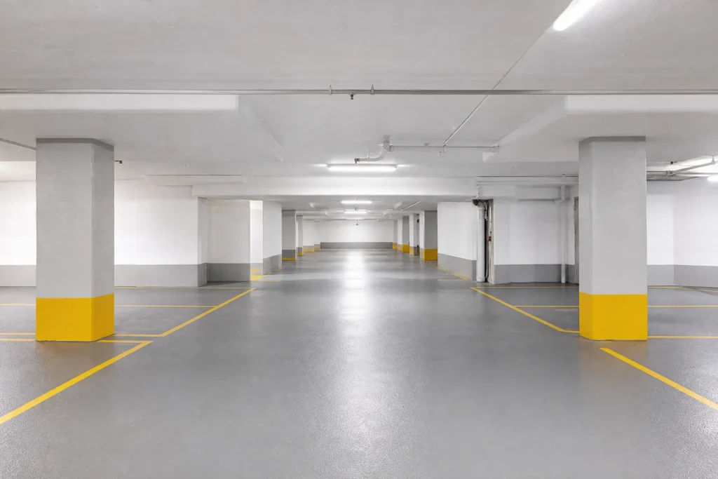 Parking garage level freshly painted white with grey columns and fresh yellow lines