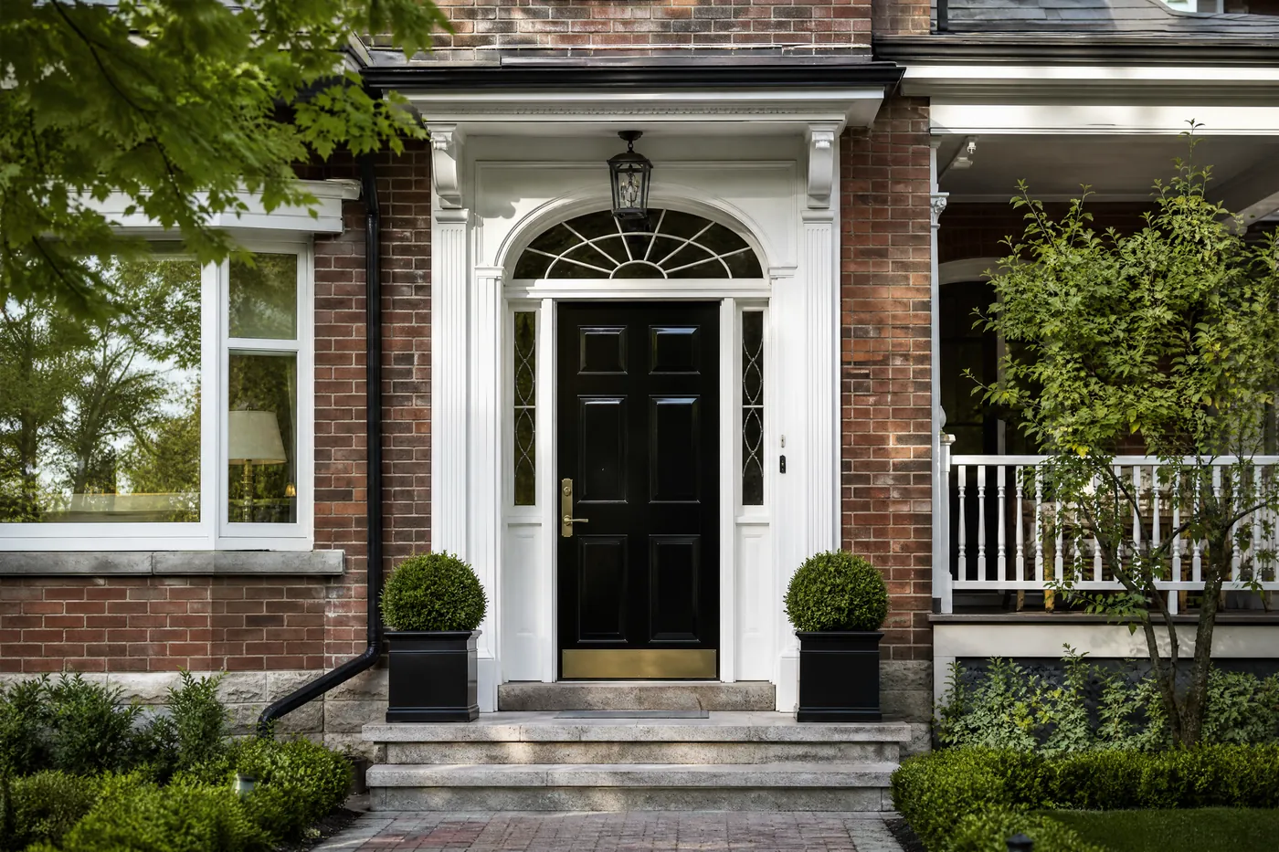 Freshly refinished glossy black front door with brass hardware