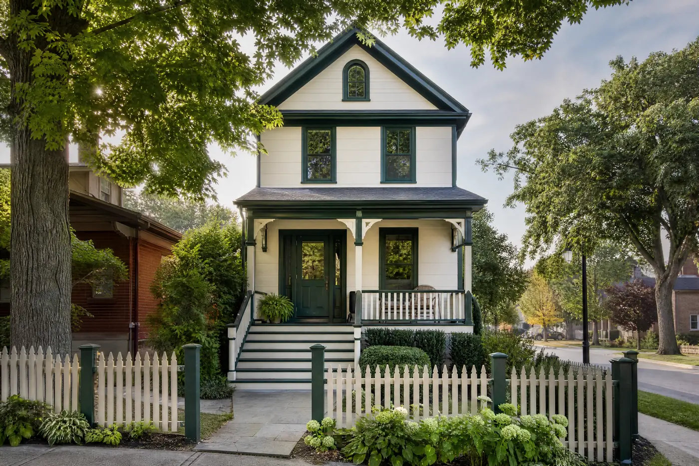 Heritage village house freshly painted cream with green trim